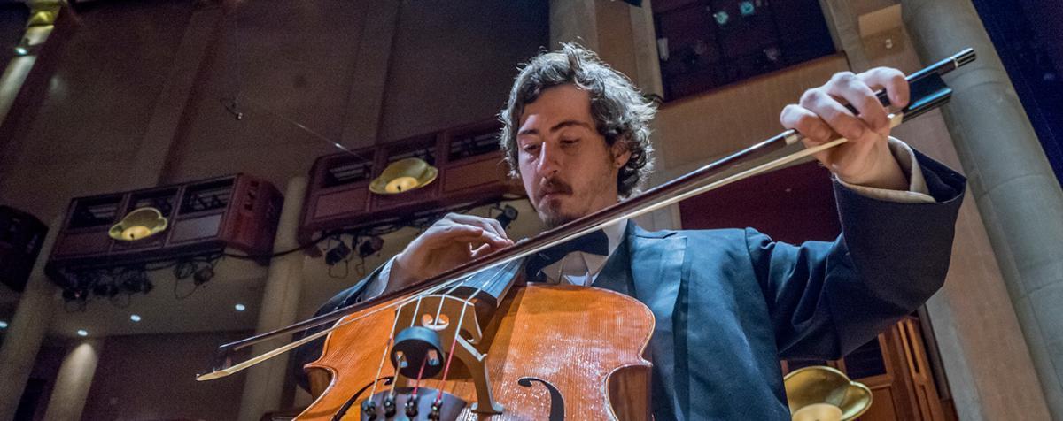 Man plays cello at a University of Denver performance